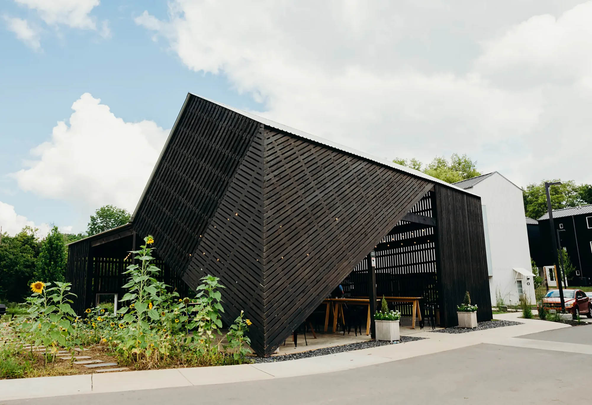 Architectural, geometric pavillion next to sunflowers