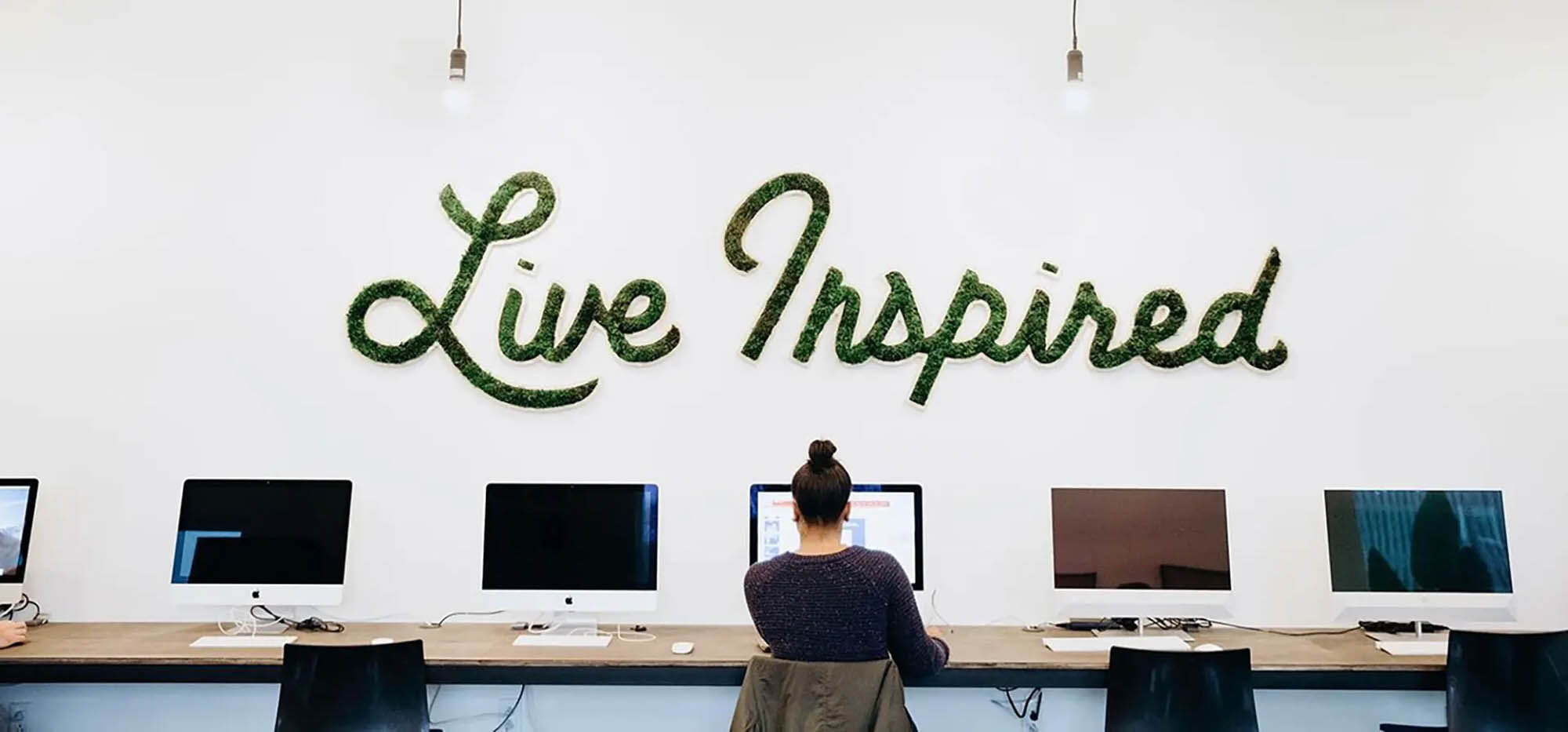 Computer lab with greenery installation that says Live Inspired