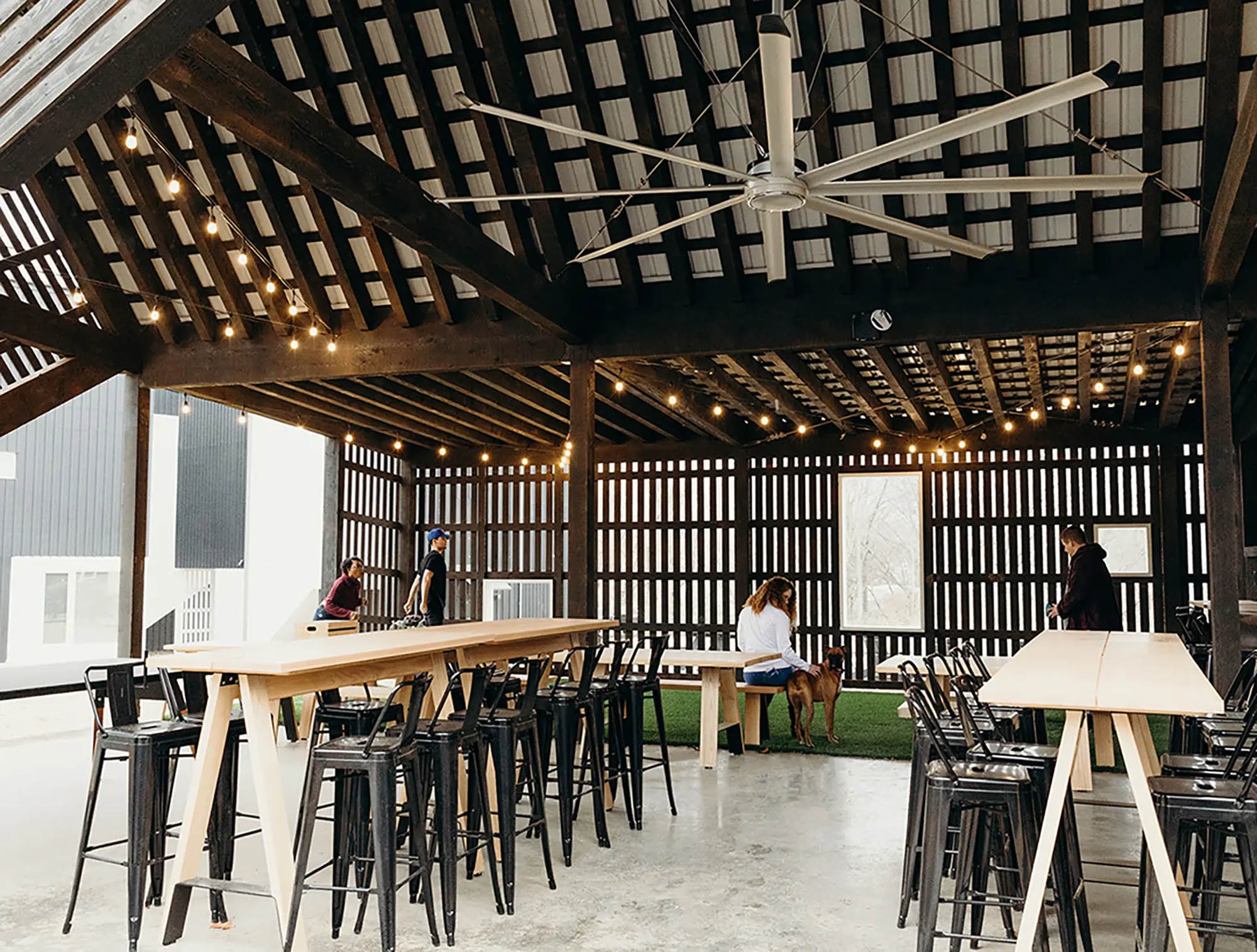 Exterior clubhouse or barn with communal tables and green space for residents to use