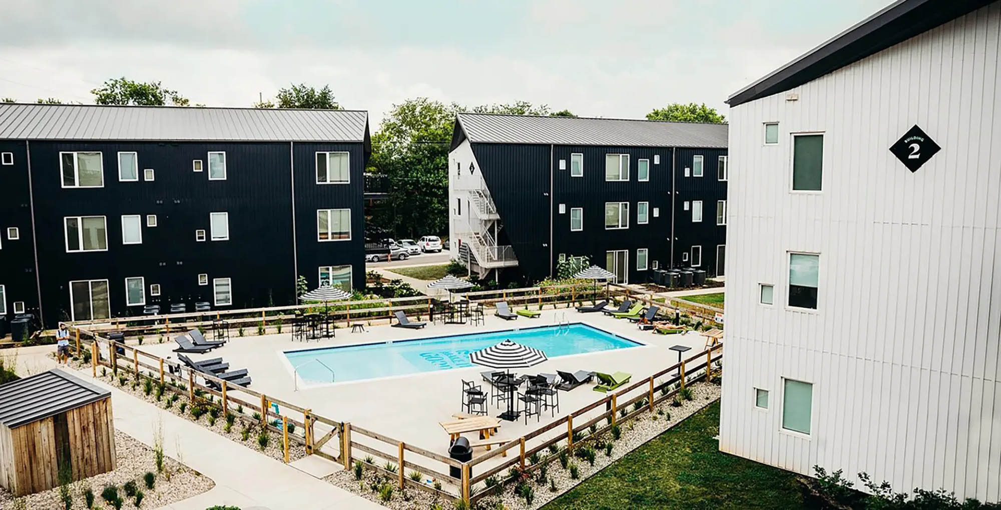 High contrast, modern apartment complex with inviting pool in the middle
