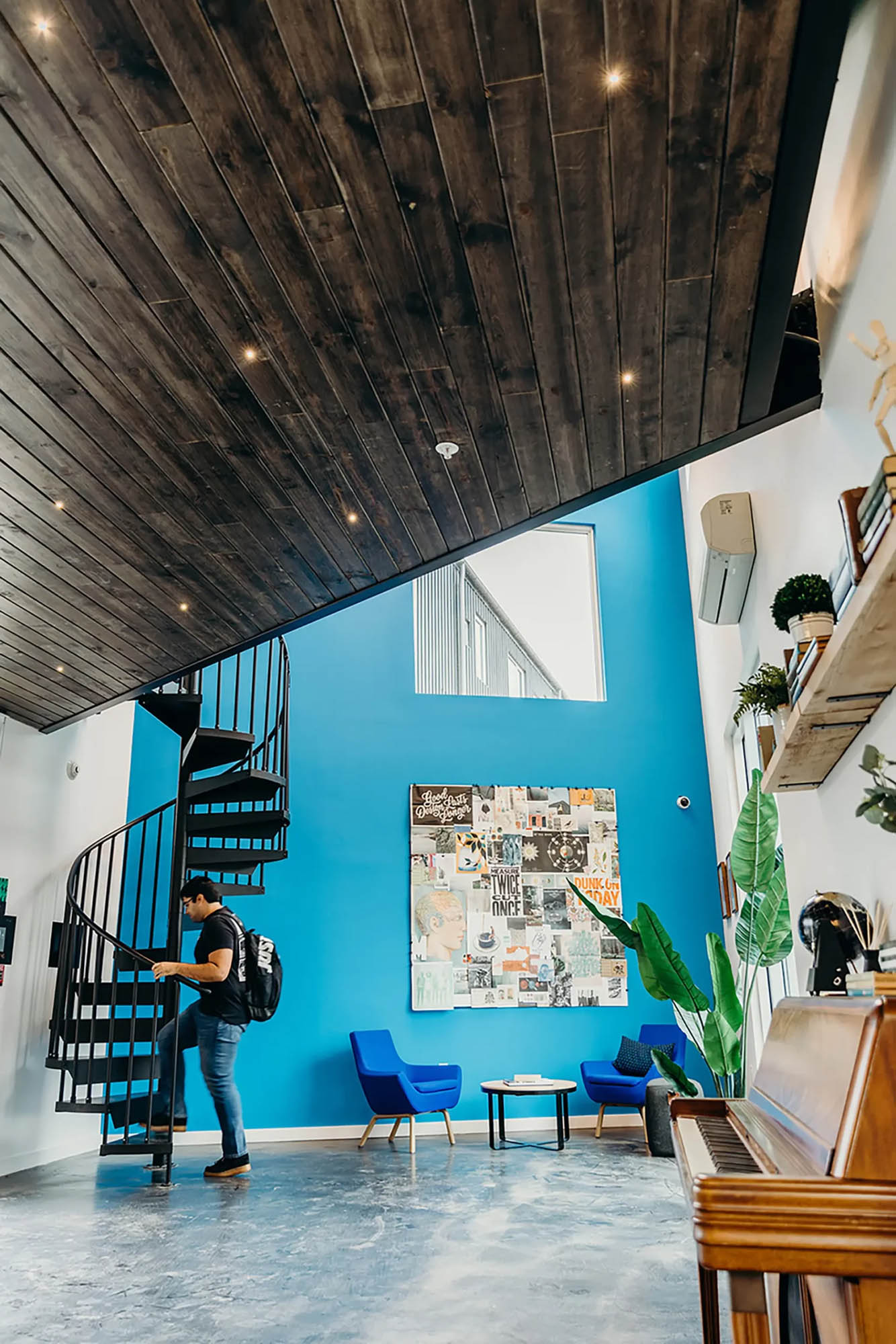 Man climbs staircase with a bright blue accent wall behind him
