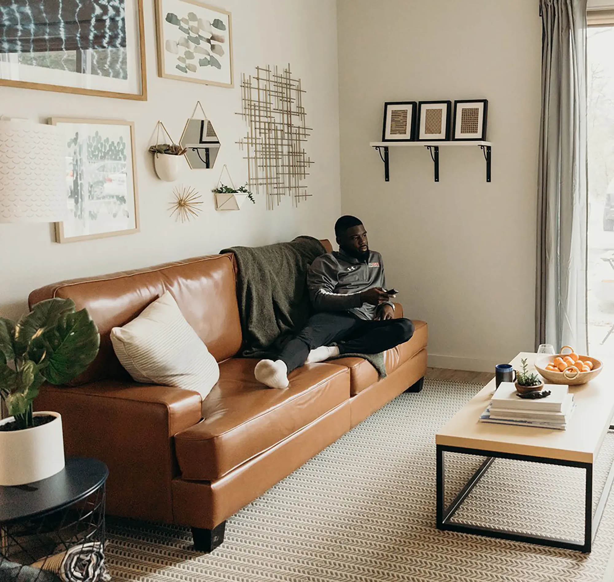 Man lounging on leather couch in clean and modern living room